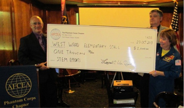 In October, Col. Van Dyke (l) and Col. Crooks present a $1,000 STEM Teaching Tools grant to Maureen Adams, principal of West Ward Elementary School.